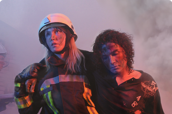 A woman firefighter rescuing a lady in a fire 